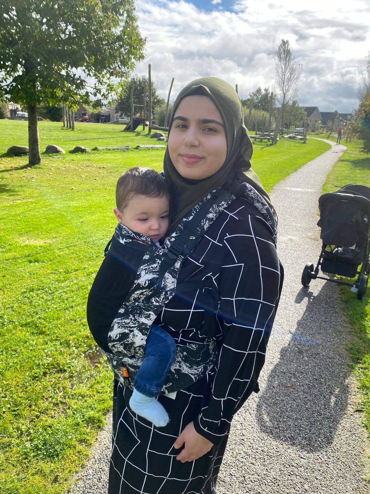Een baby in een draagzak op een wandelpad