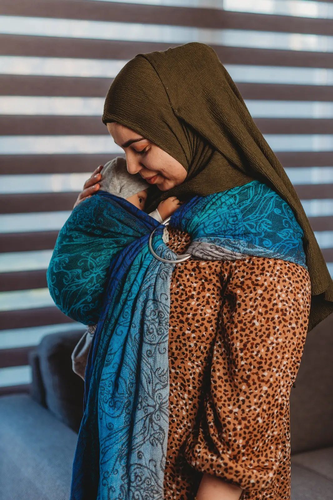 Feride binnen met een blauwe ringsling tegen een streepwand
