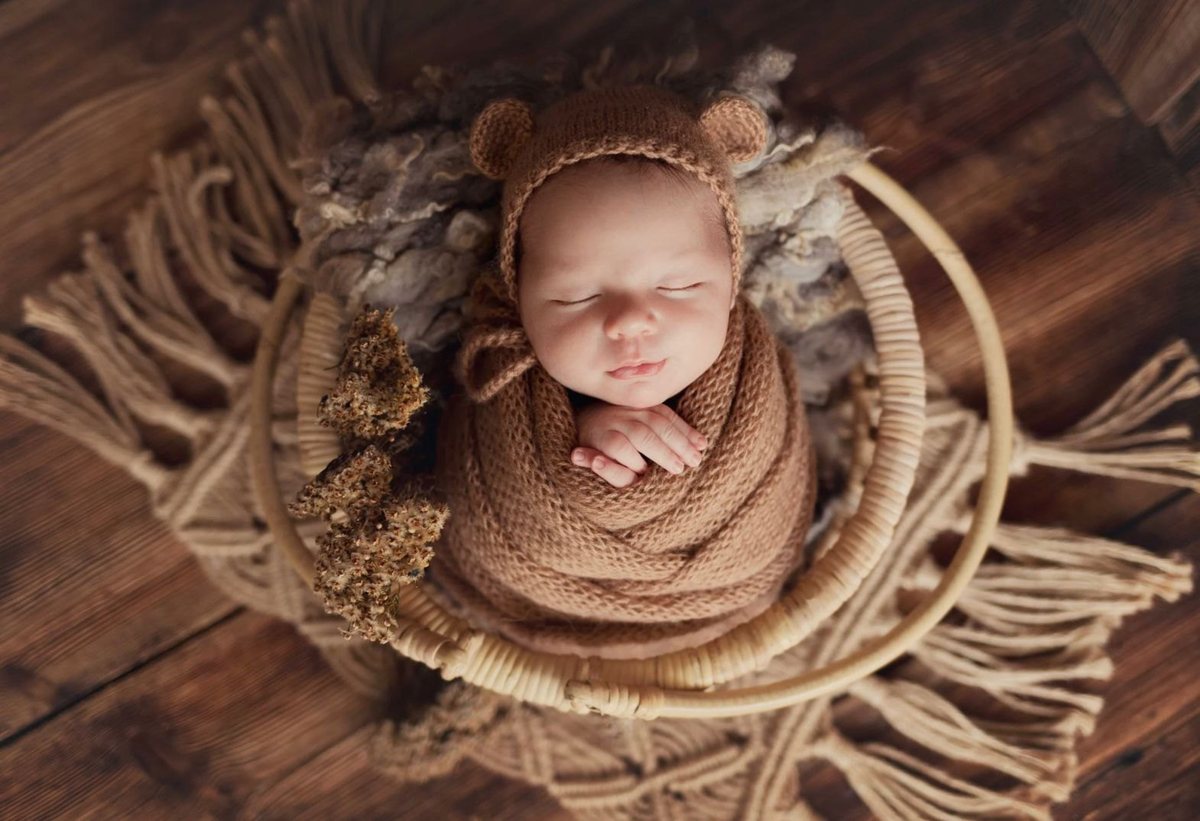 Slapende pasgeboren baby in een gebreid mutsje